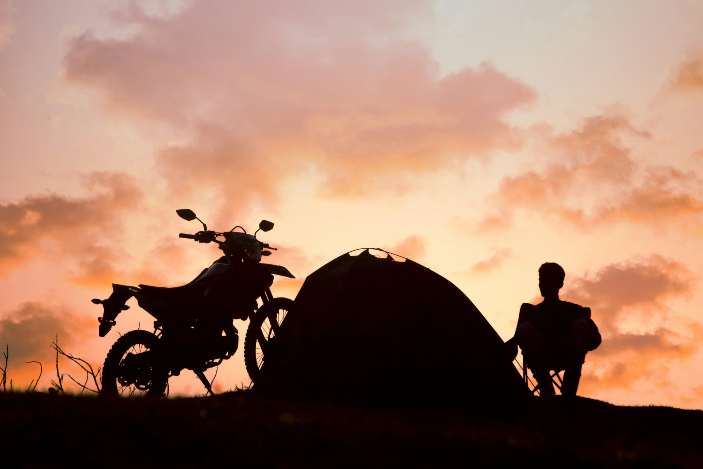 Motorrad und Zelt in der Abenddämmerung
