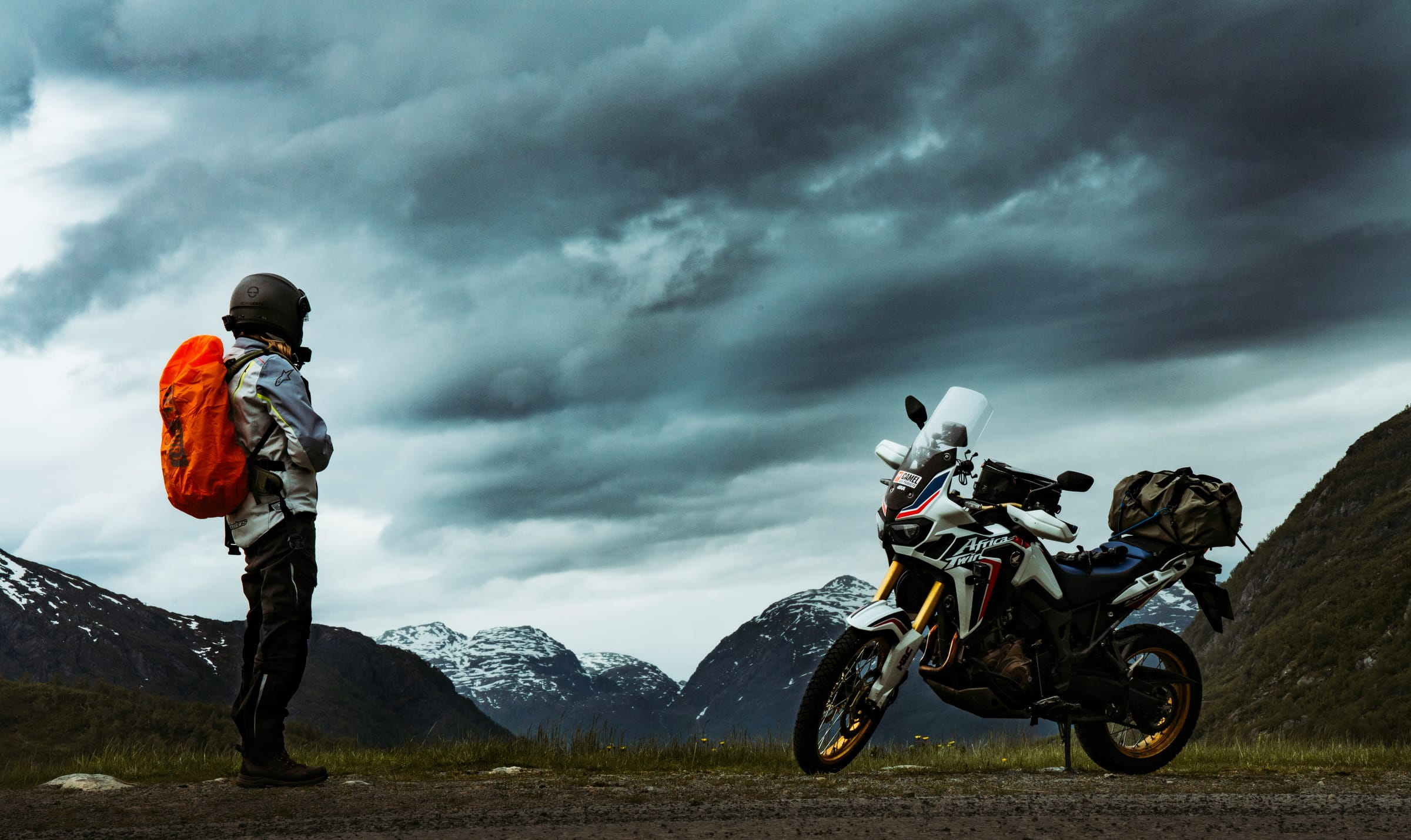Reise-Enduro und Fahrerin vor Bergpanorama